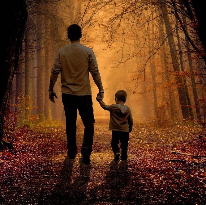 Hier ist ein Vater mit seinem Sohn im Wald spazieren.
