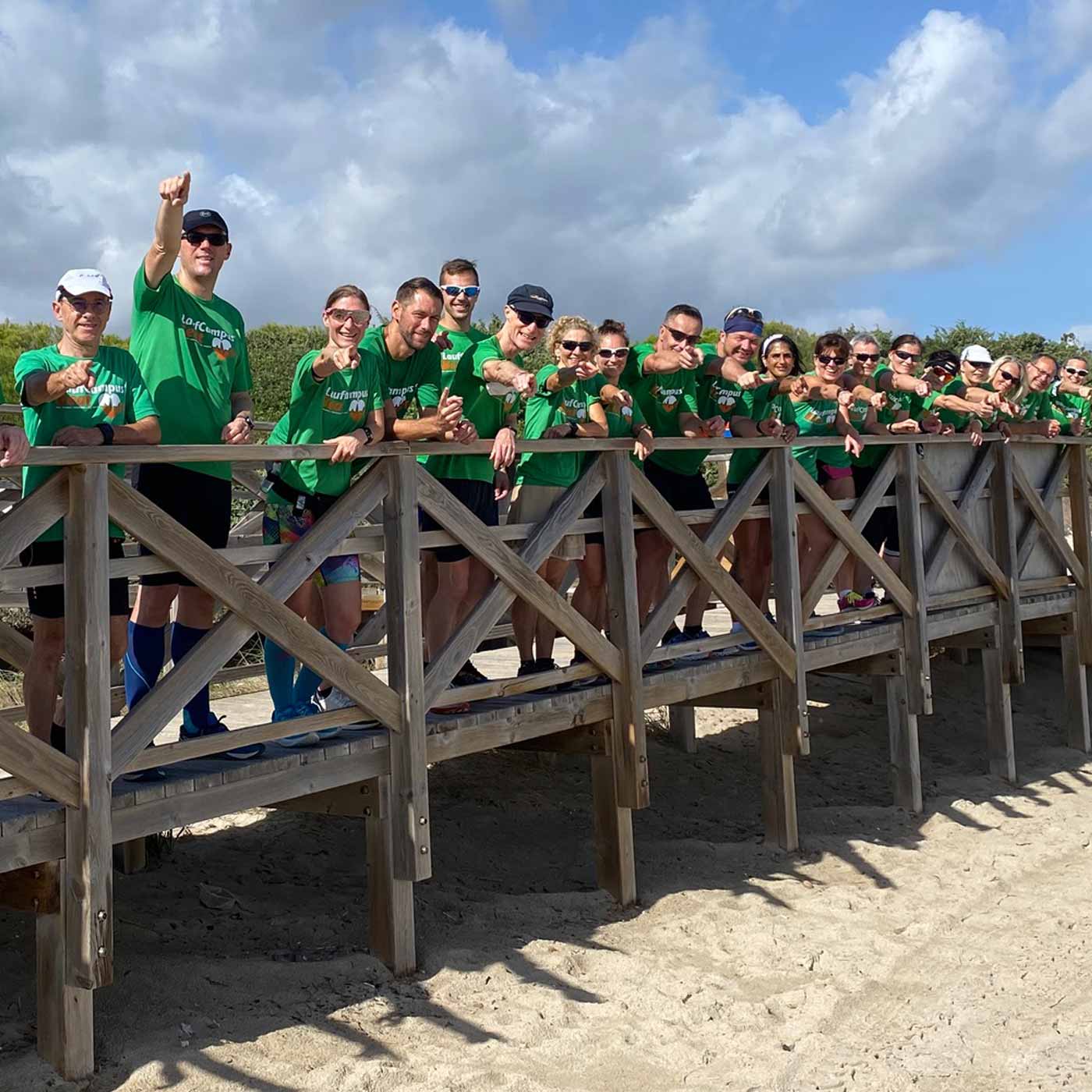 Läufer grüßen von einem Steg bei einem Laufcamp auf Mallorca