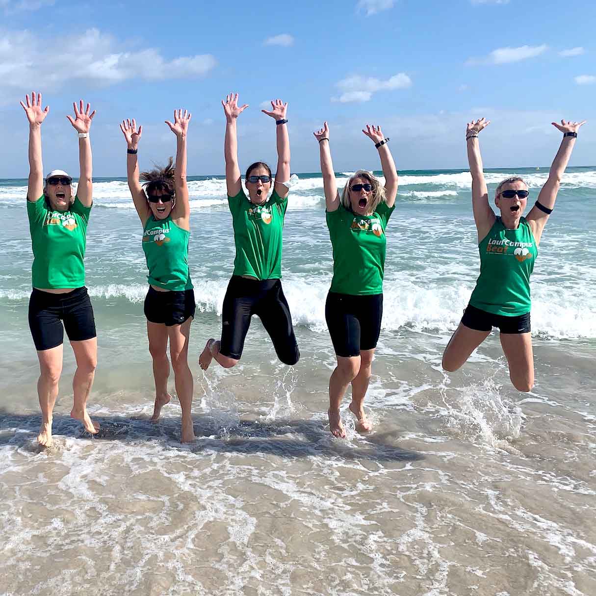 Fünf Läuferinnen stehen beim Mallorca Laufcamp im Wasser am Strand auf Mallorca.