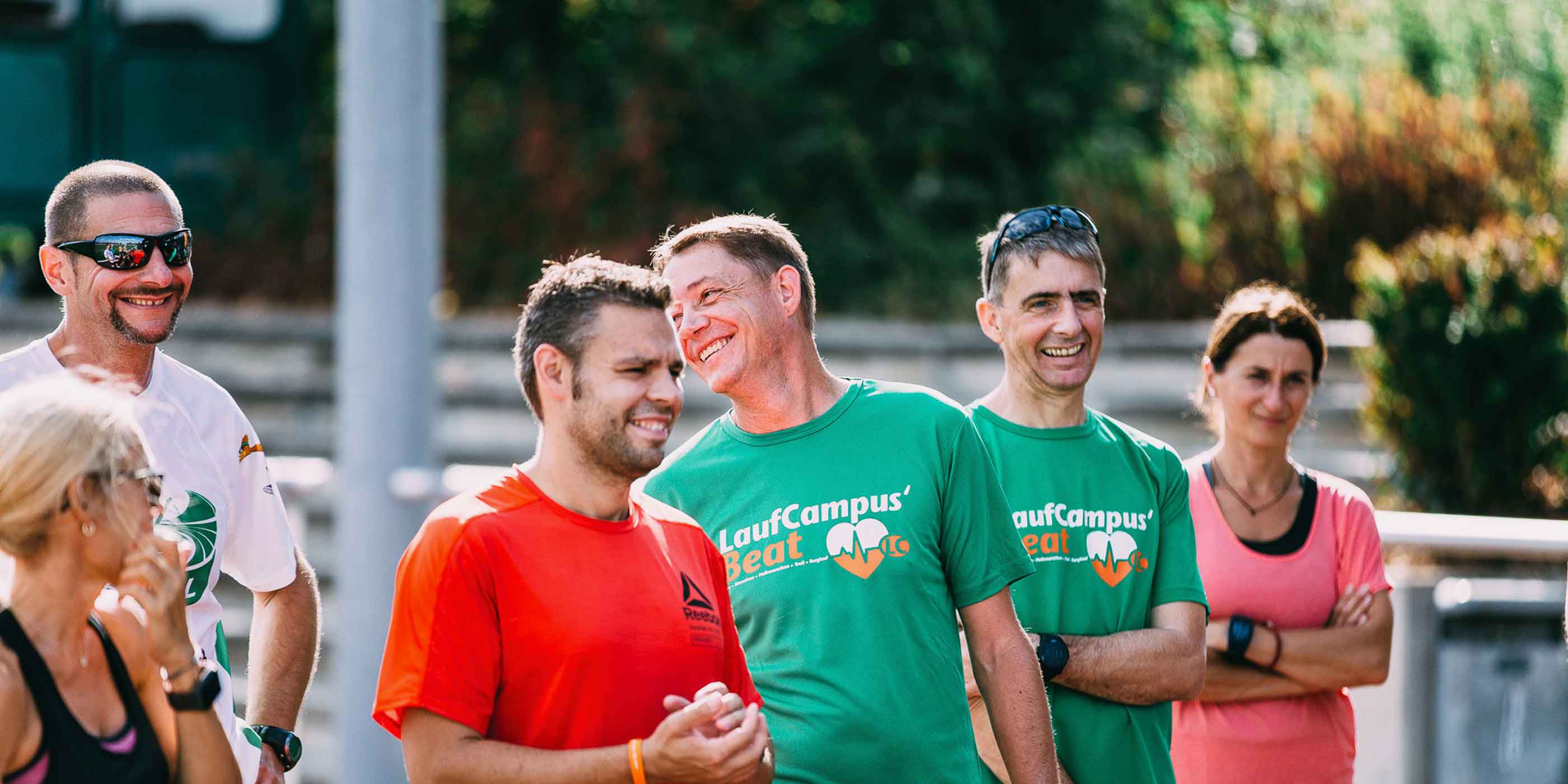 Eine Gruppe Läuferinnen und Läufer lachen bei einem Seminar der Lauftrainer Ausbildung