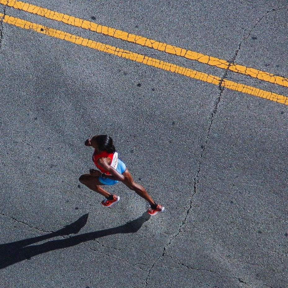 Läuferin joggt auf der Straße. Durch das Laufen werden die Mitochondrien gestärkt.
