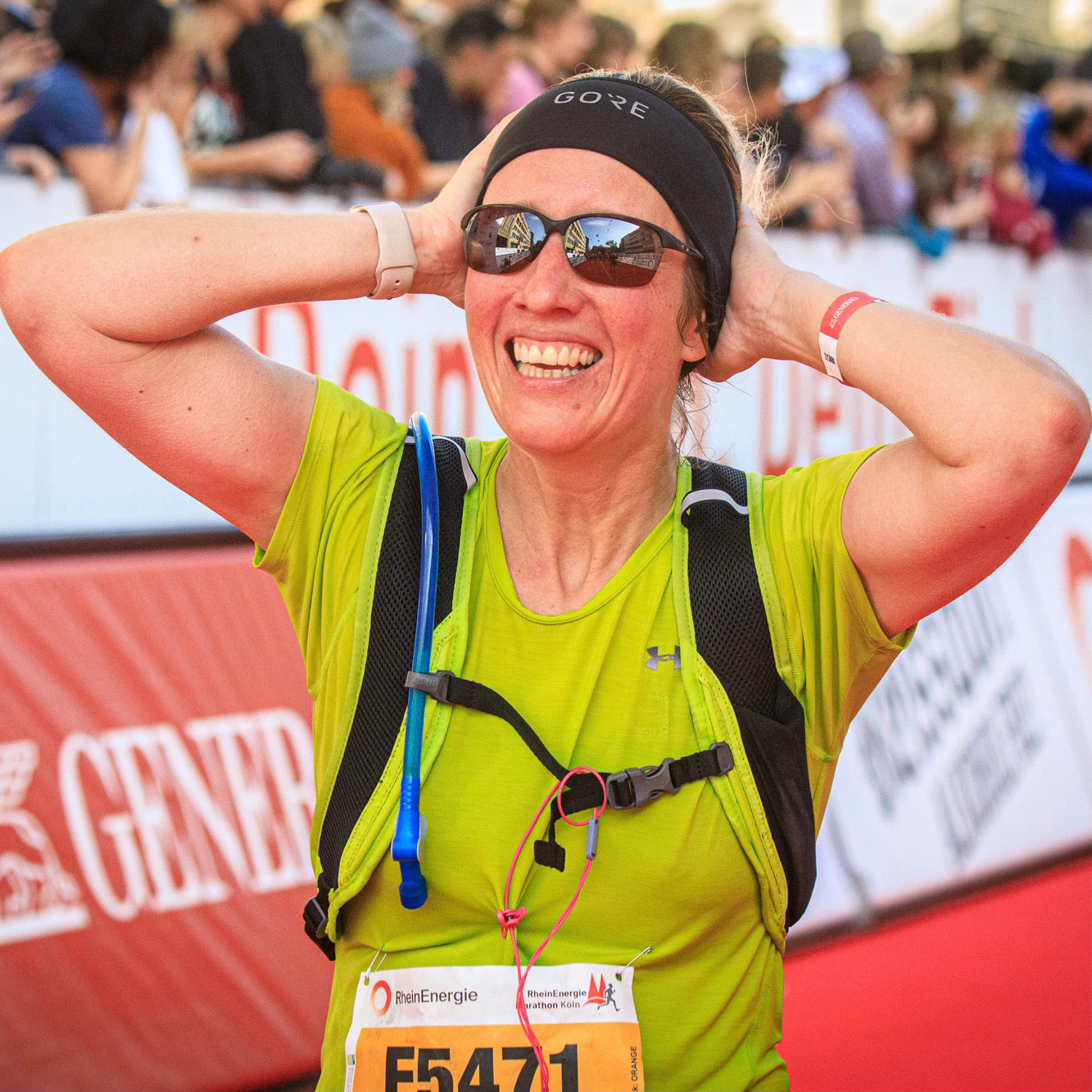 Hier ist eine glückliche Marathonteilnehmerin zu sehen, die durch das Ziel gelaufen ist.