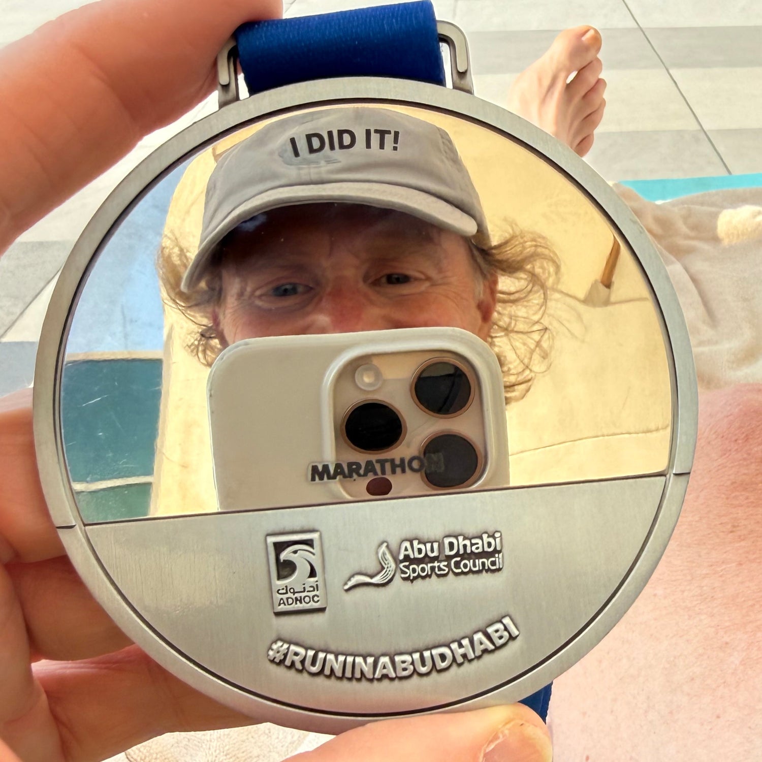 Marathon Globetrotter Andreas im Spiegel der Medaille vom Abu Dhabi Marathon