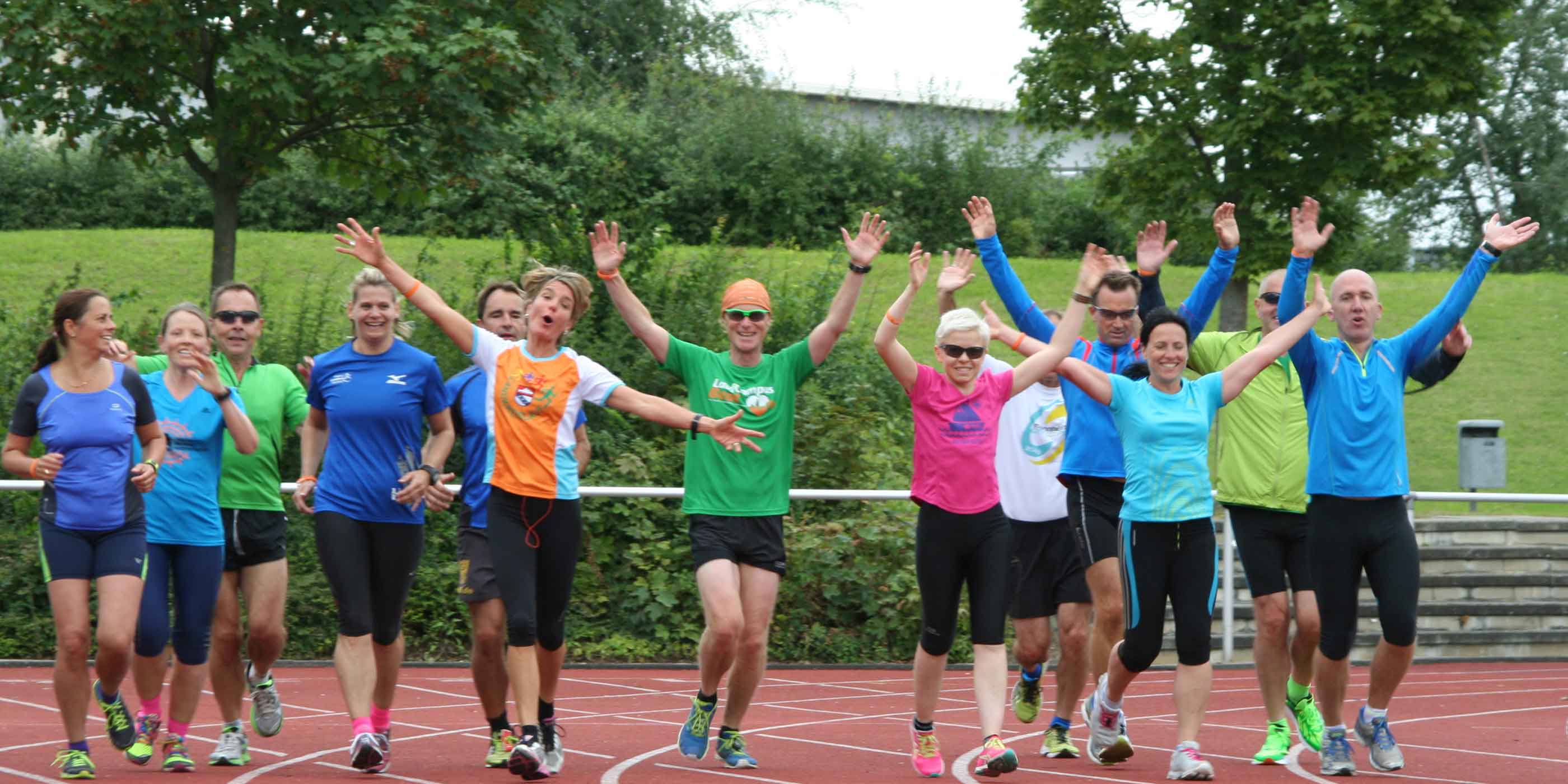 Jubelnde Läuferinnen recken die Arme hoch, auf einer Tartanbahn im Erftstadion Euskirchen anlässlich einem Seminar der Lauftrainer Ausbildung